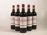 quatre bouteilles de vin sont alignées sur une surface blanche
