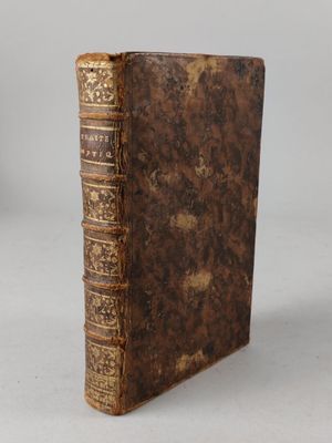an old book sitting on top of a table next to a white wall