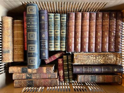 de nombreux livres anciens dans une boîte posée sur une étagère