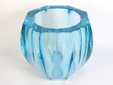 a blue glass vase sitting on a white surface