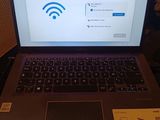 a laptop that is sitting on a table with a wifi sign on the screen