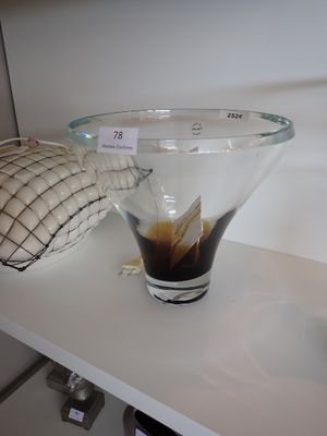 un bol en verre rempli de liquide et un oreiller posé sur une étagère