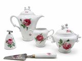 an image of a white tea set with pink roses and a knife