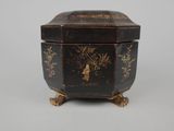 an old black and gold box with a bird on it