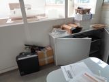 a room with a table, a refrigerator, and a suitcase in it