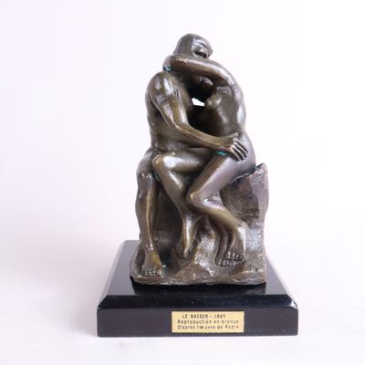 statue représentant un homme assis sur un rocher, les mains sur le visage
