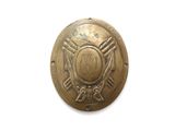 une vieille plaque en laiton sur laquelle figure l'emblème des pompiers
