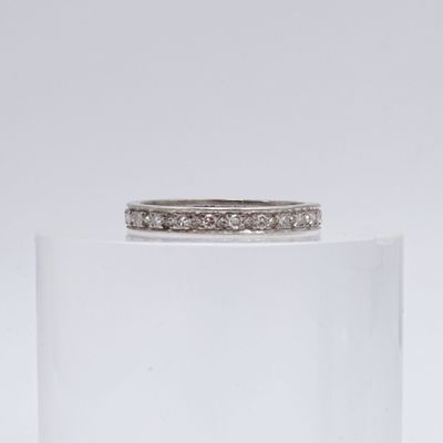 a close up of a diamond ring sitting on top of a clear glass