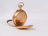 an image of a gold pocket watch sitting on top of a saucer