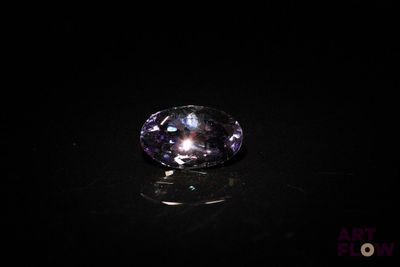 a close up of a purple diamond on a black surface