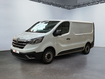 La camionnette blanche est garée dans une grande pièce aux murs blancs.