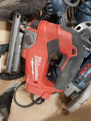 a red corded drill and other tools in a box