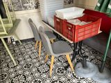 plusieurs chaises et une table dans une pièce au sol carrelé noir et blanc