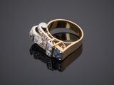 a close up of a gold ring with a sapphire and diamonds