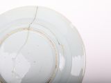 a white plate with a crack in the middle of it