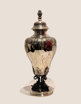 a silver vase with a lid sitting on a table