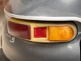 a close up of a car ' s tail light with a brick wall in the background