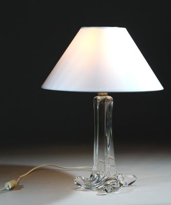 une lampe posée sur une table, avec un abat-jour blanc