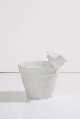 un bol blanc contenant une fleur, posé sur une table