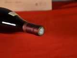 a bottle of wine sitting on a red table cloth