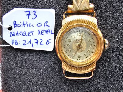 une montre-bracelet en or à laquelle est attachée une étiquette de prix