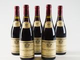 four bottles of wine are lined up on a white surface