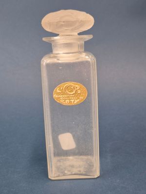 a small glass bottle with a gold label on it