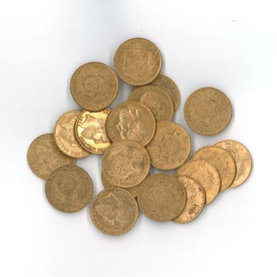 quelques pièces d'or sont éparpillées sur une surface blanche, sur fond blanc
