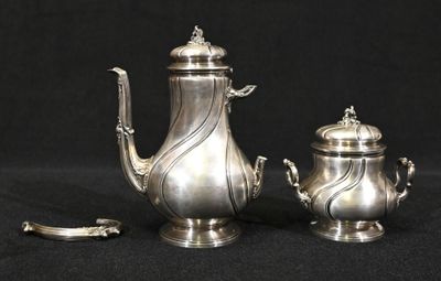une théière en argent et une théière en argent sur fond noir
