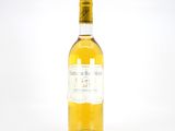 une bouteille de vin blanc posée sur une table blanche