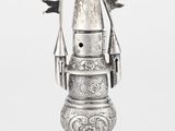 un vieux vase en argent surmonté d'un drapeau