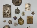 plusieurs médailles d'argent et d'or ainsi que d'autres objets posés sur un fond blanc