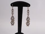 a close up of a pair of earrings on a black stand