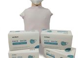 trois boîtes de masques faciaux et une tête de mannequin sur fond blanc