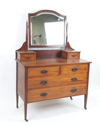 une commode en bois surmontée d'un miroir