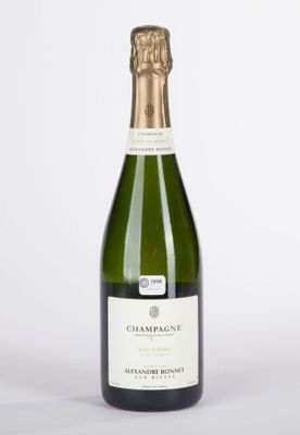 la bouteille de champagne est posée sur une surface blanche