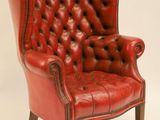 une image représentant un fauteuil en cuir rouge posé sur un sol blanc