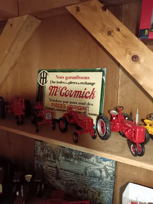 many toy tractors on a shelf in a room