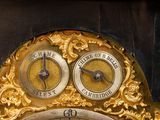 a gold clock that has two different faces on it