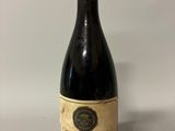 an old bottle of wine sitting on top of a table