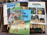 many books that are in a box on the floor