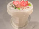 a small white vase with pink flowers on it