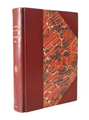 un vieux livre à la couverture rouge posé sur une surface blanche