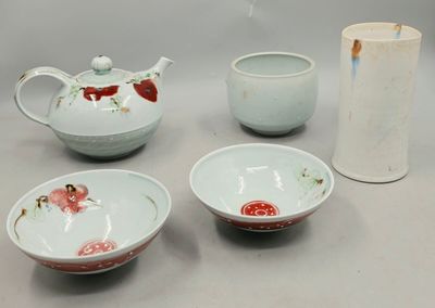 four bowls, a teapot, and a vase on a table