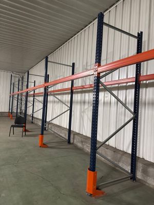 rayonnages d'entrepôt dans un entrepôt avec des montants orange et un mur blanc