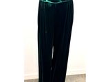 Le mannequin porte un pantalon en velours vert et un haut blanc.