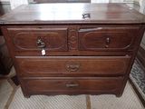 une commode en bois surmontée d'un miroir