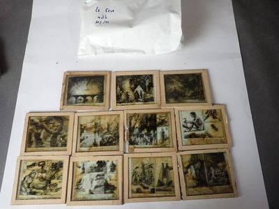 beaucoup de vieilles photos posées sur une table, à côté d'un sac