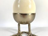 a white egg sitting on top of a metal stand