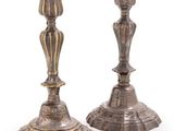 pair of antique silver candlesticks on a white background